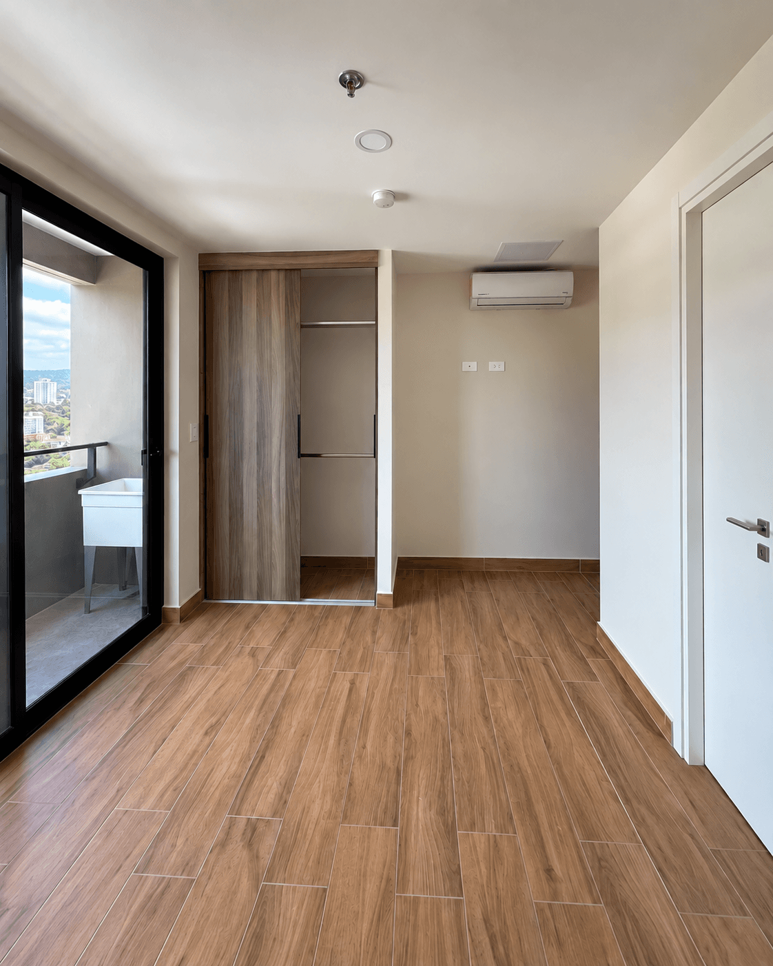Ambiente principal con clóset, aire acondicionado y salida al balcón panorámico
