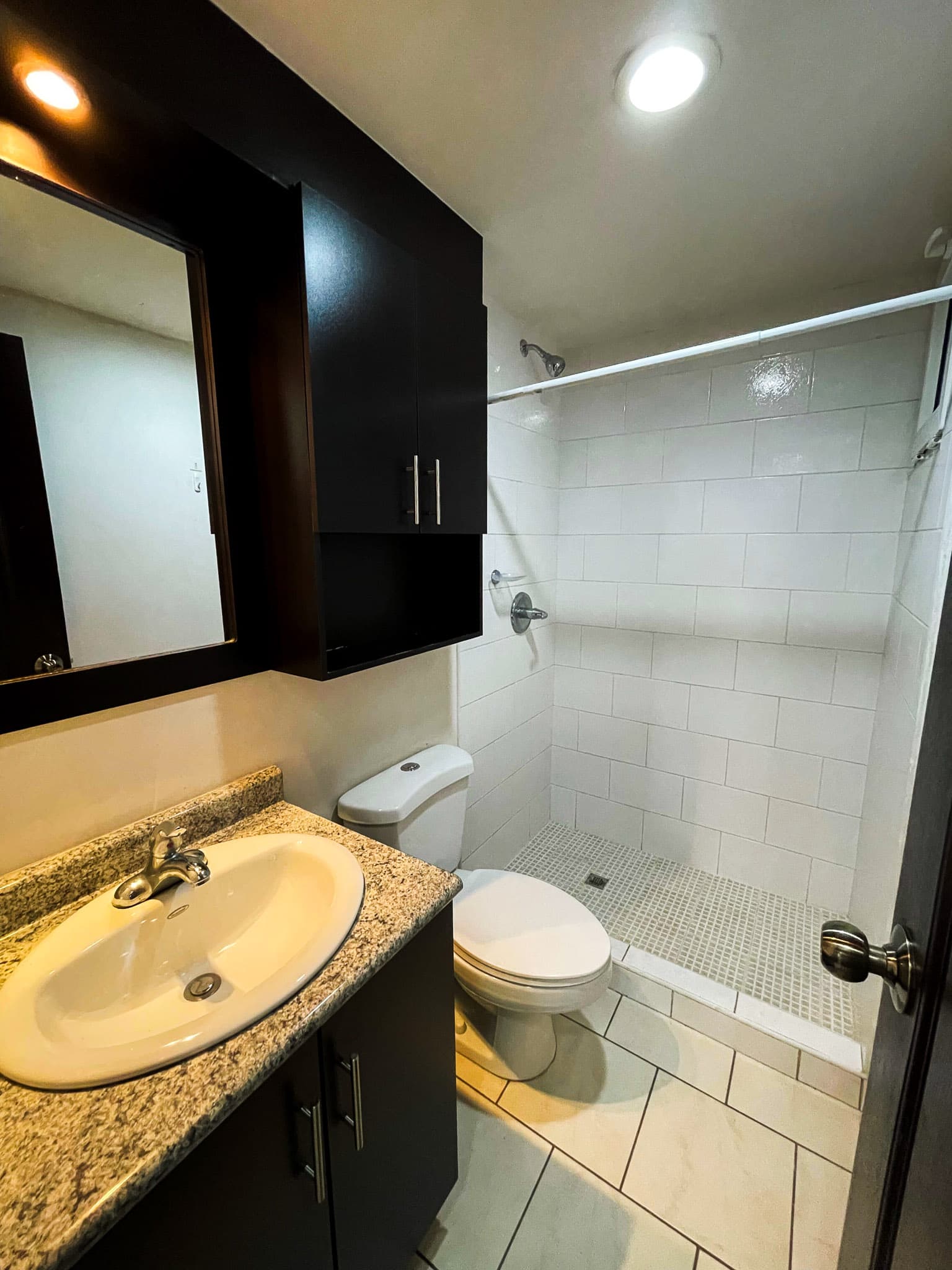 Segundo baño con ducha, inodoro y vanity de granito