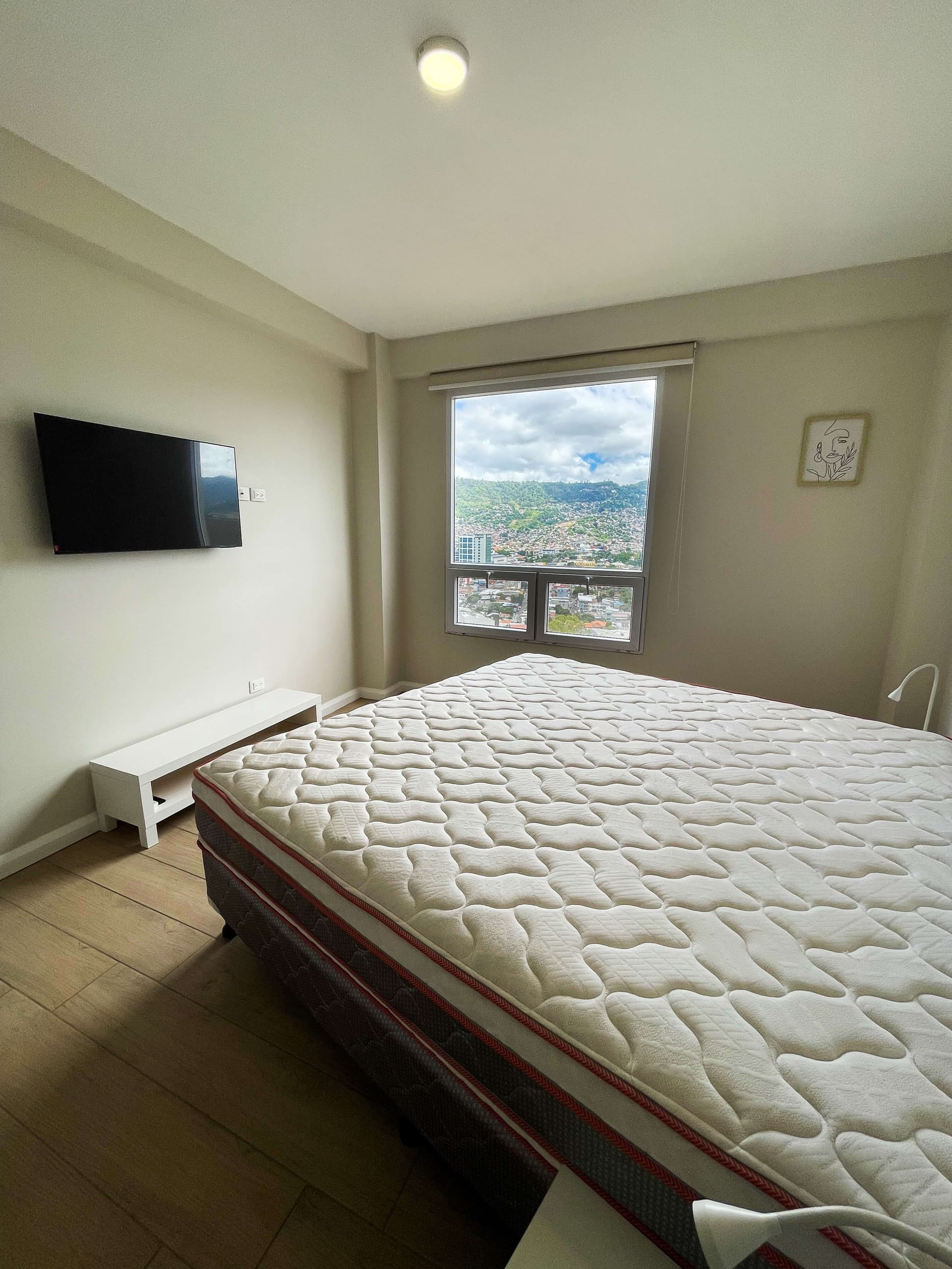 Habitación principal con cama King y ventana con vista panorámica
