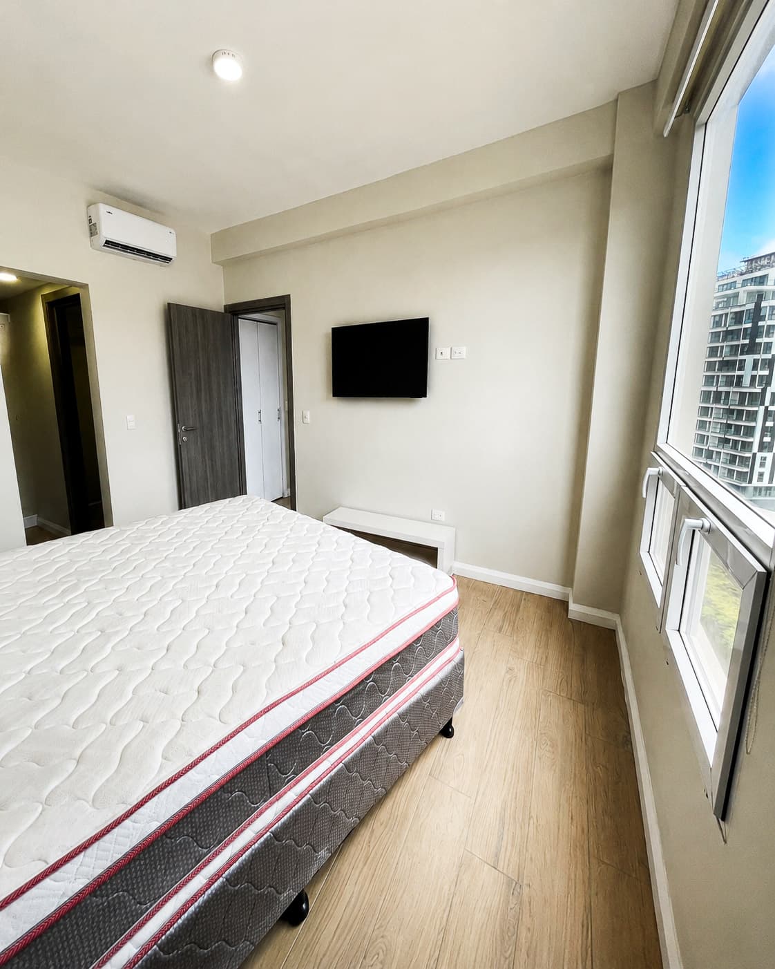 Habitación principal con cama King, aire acondicionado y TV