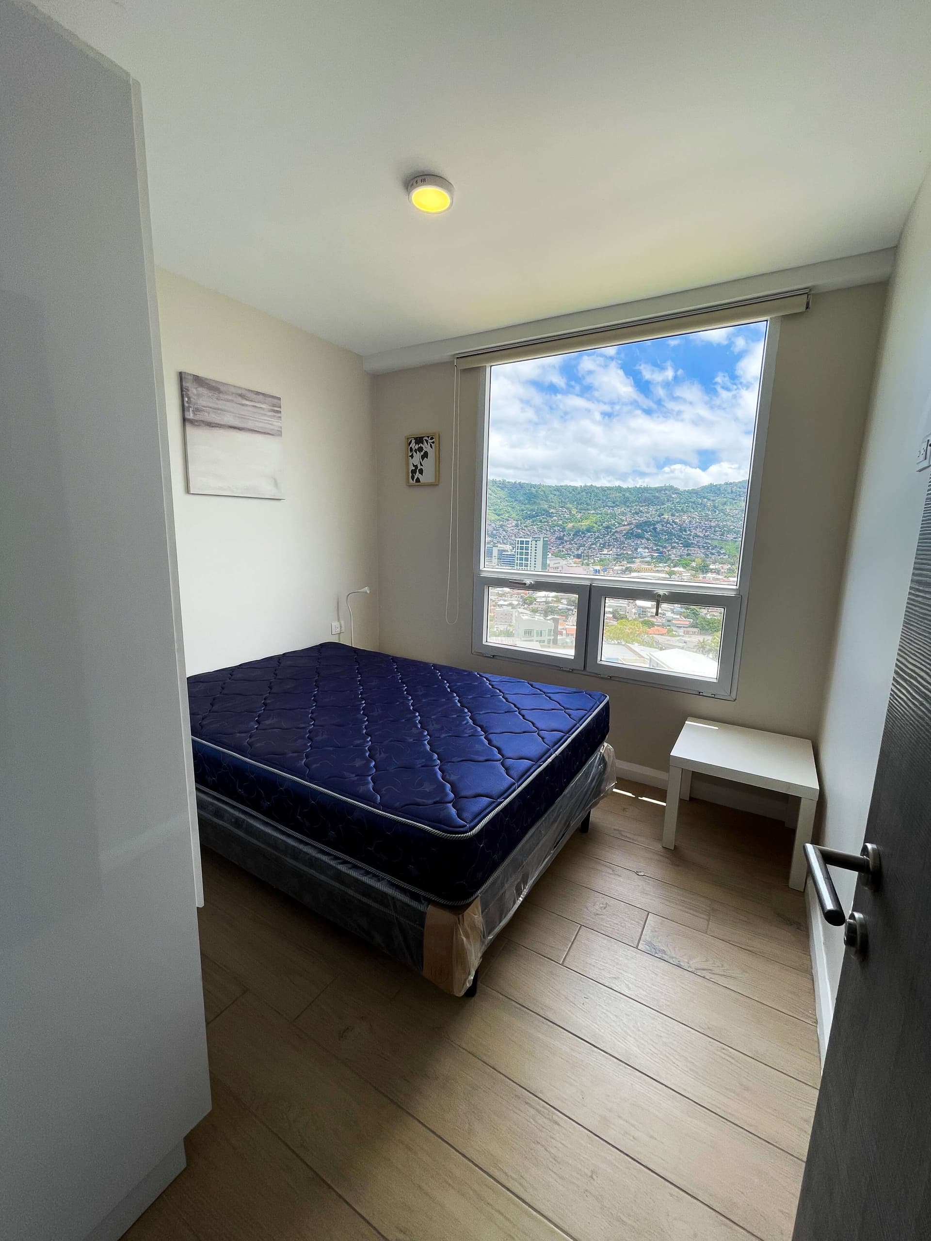 Habitación secundaria con cama matrimonial y ventana con vista